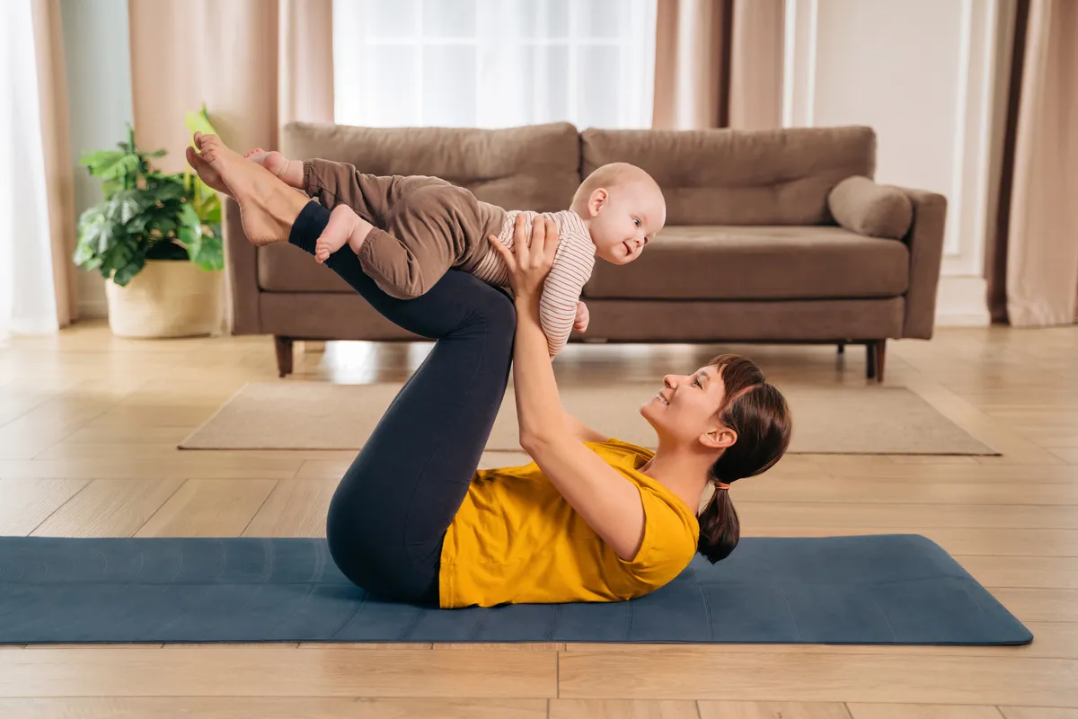 Woman during a postnatal recovery yoga class with her child in London ON
